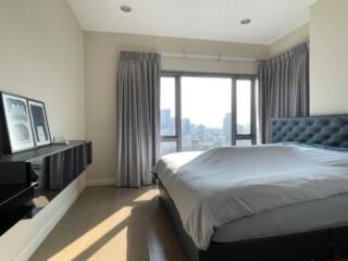 Spacious bedroom with large bed and panoramic city view