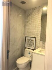 Modern bathroom with tiled walls, toilet, and sink