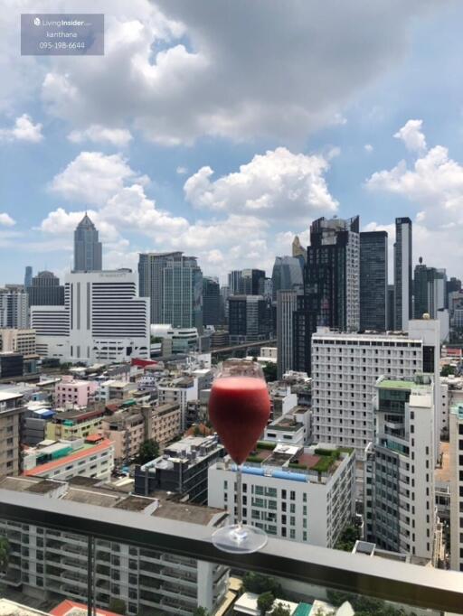 Urban view from balcony with a glass of wine