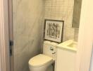 Modern bathroom with marble tiles and wall art