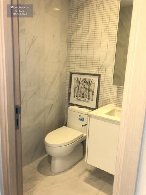 Modern bathroom with marble tiles and wall art