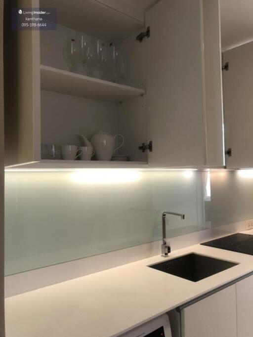 Modern kitchen with open cabinets, glass backsplash and sink