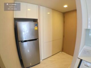 Modern kitchen with stainless steel refrigerator and white cabinets