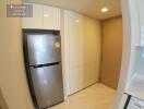 Modern kitchen with stainless steel refrigerator and white cabinets