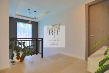 Bright hallway with modern lighting, railing, and indoor plants