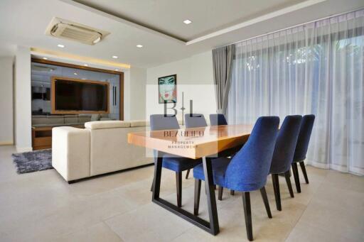 Modern living room and dining area with contemporary furnishings and large windows