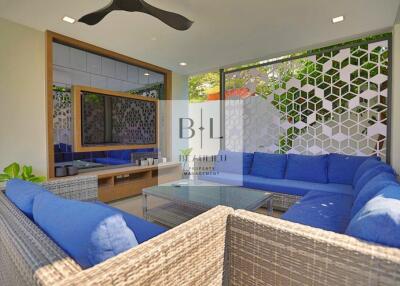 Modern outdoor living area with blue cushioned seating and glass coffee table