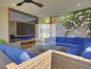 Modern outdoor living area with blue cushioned seating and glass coffee table