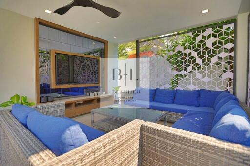 Modern outdoor living area with blue cushioned seating and glass coffee table