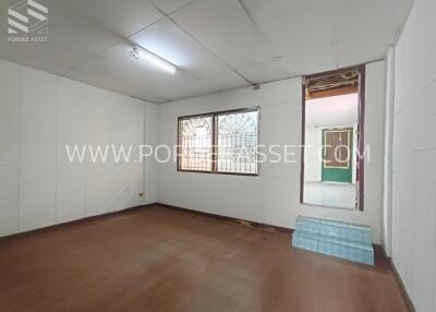 Spacious bedroom with a window and wooden flooring