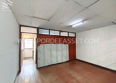 Empty room with wooden floor and fluorescent lighting