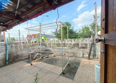 Covered backyard area with tiled floor and metal structures