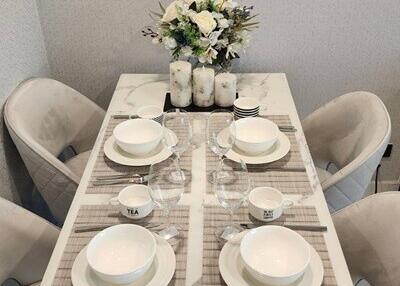 Modern dining table set with tableware and flower arrangement