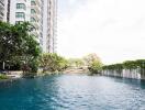 View of a swimming pool in an apartment complex with surrounding greenery