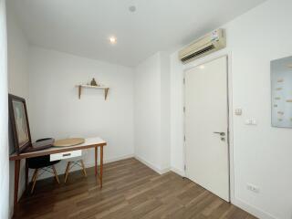 Well-lit home office with desk and wall-mounted shelf