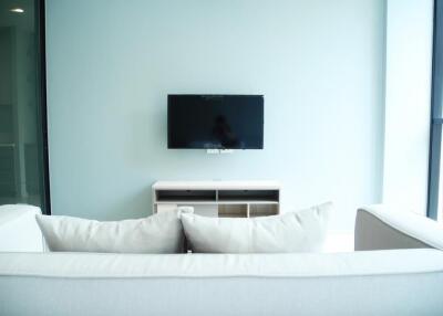 Modern living room with wall-mounted TV and white sofa