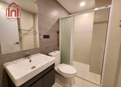 Modern bathroom with sink, toilet, and shower area.