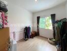 Bedroom with large window and various stored items