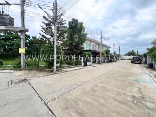 Residential building with driveway and surrounding greenery