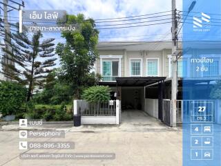 Front view of a two-story townhouse with a driveway and small garden