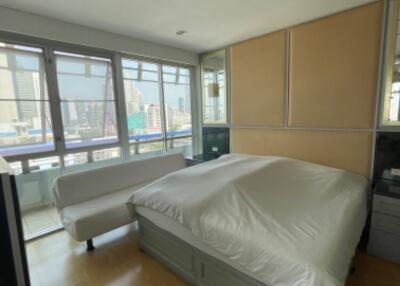 Spacious bedroom with large windows and city view