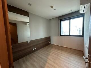 Empty bedroom with wood flooring and large window