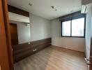 Empty bedroom with wood flooring and large window