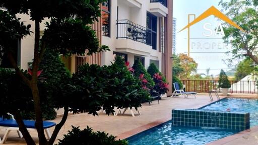 Outdoor pool area with lounge chairs and landscaped surroundings