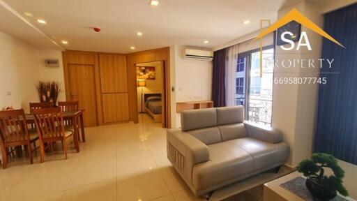 Spacious living room with dining area and view into the bedroom