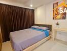 Bedroom with a bed, side table, painting, and brown curtains