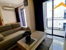 Modern living room with sofa, coffee table, and balcony access