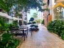 Outdoor seating area with lush greenery and tiled walkway