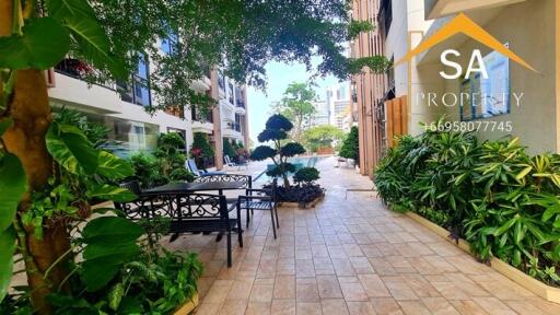 Outdoor seating area with lush greenery and tiled walkway