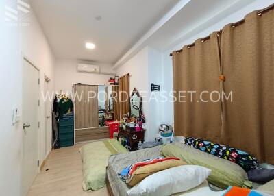 Spacious bedroom with bed, wardrobe, air conditioner, brown curtains, and various furnishings