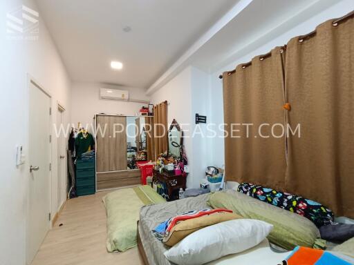 Spacious bedroom with bed, wardrobe, air conditioner, brown curtains, and various furnishings