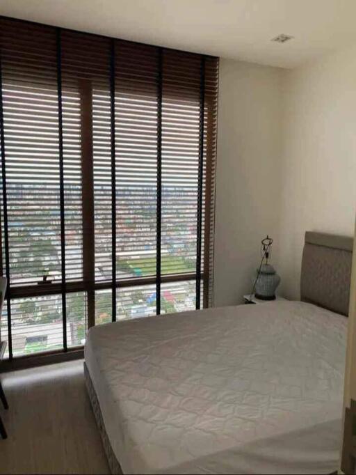 Bedroom with a large window and blinds