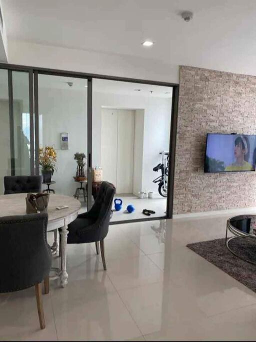 Modern living room with a view into a glass-walled workout area