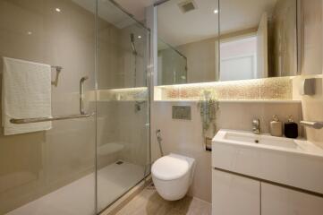 Modern bathroom with glass shower, floating toilet, and contemporary sink