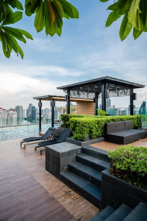 Modern rooftop terrace with pool, city view and lounge chairs