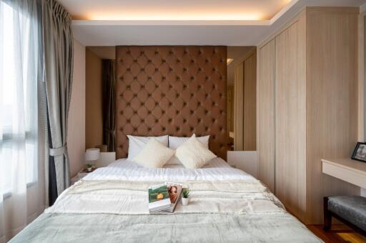 Modern bedroom with padded headboard and wooden accents