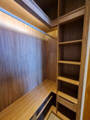 Spacious wooden built-in closet with shelves and drawers