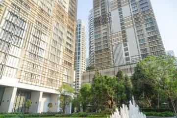 Modern apartment buildings with lush greenery and water fountain