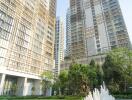 Modern apartment buildings with lush greenery and water fountain