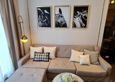 Modern living room with light grey sectional sofa, wall art, and an ottoman