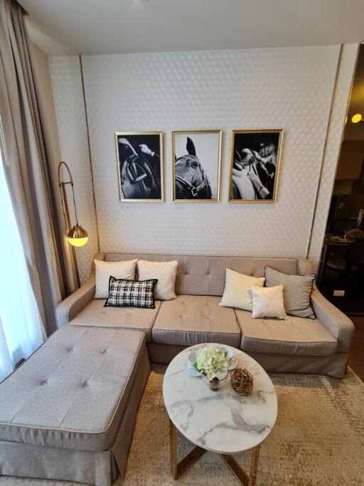 Modern living room with light grey sectional sofa, wall art, and an ottoman