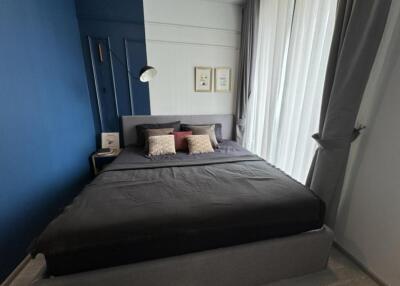 Modern bedroom with dark blue accent wall and large bed