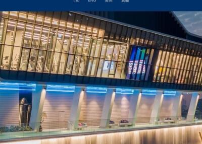 Modern building with large illuminated windows overlooking the city at dusk