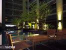 Outdoor pool area at a residential building with wooden furniture and lighting