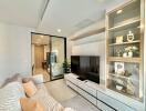 Modern living room with a comfortable sofa, built-in entertainment unit, and decorative shelving