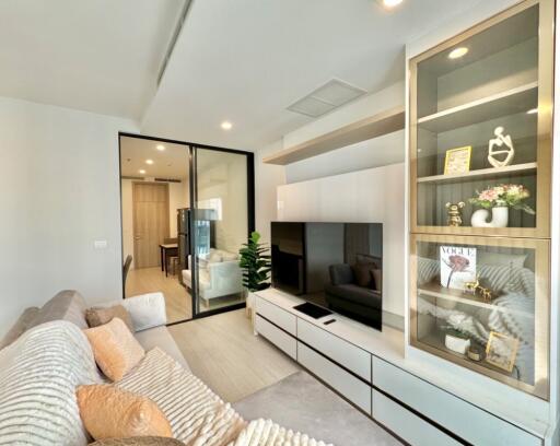 Modern living room with a comfortable sofa, built-in entertainment unit, and decorative shelving